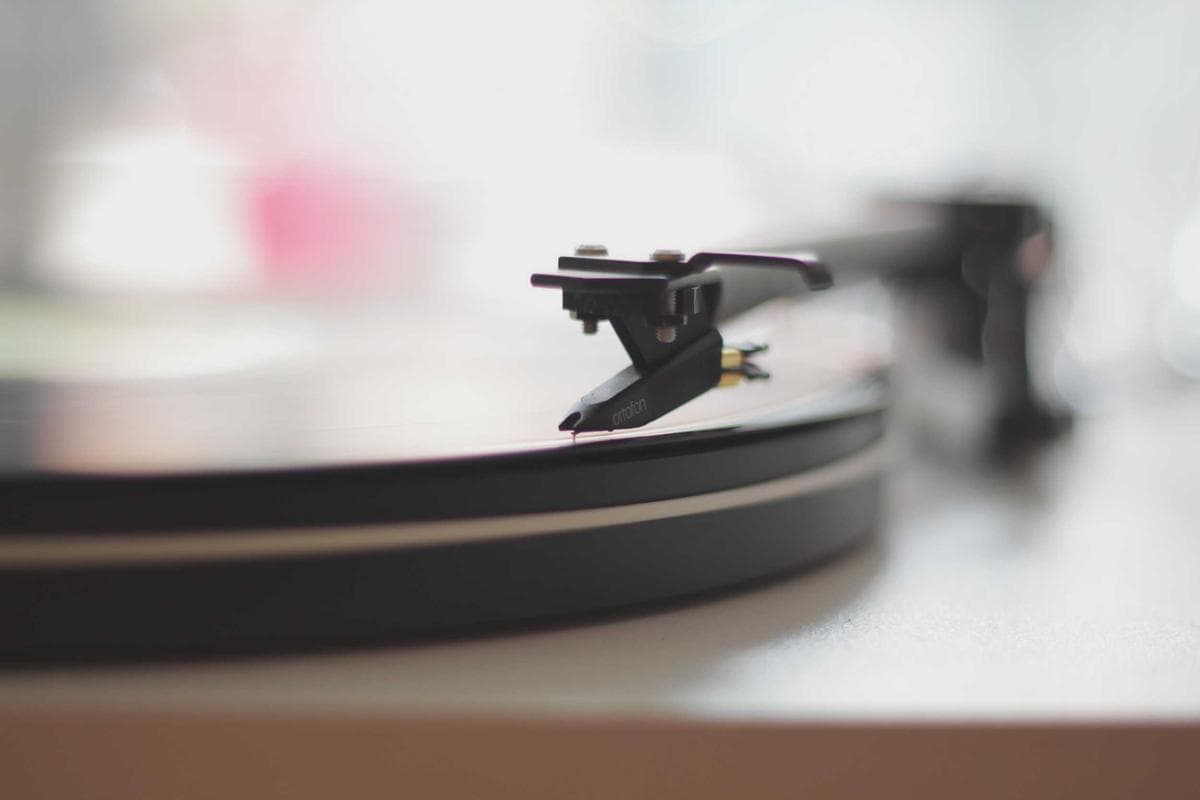 Turntable tonearm resting on a vinyl record