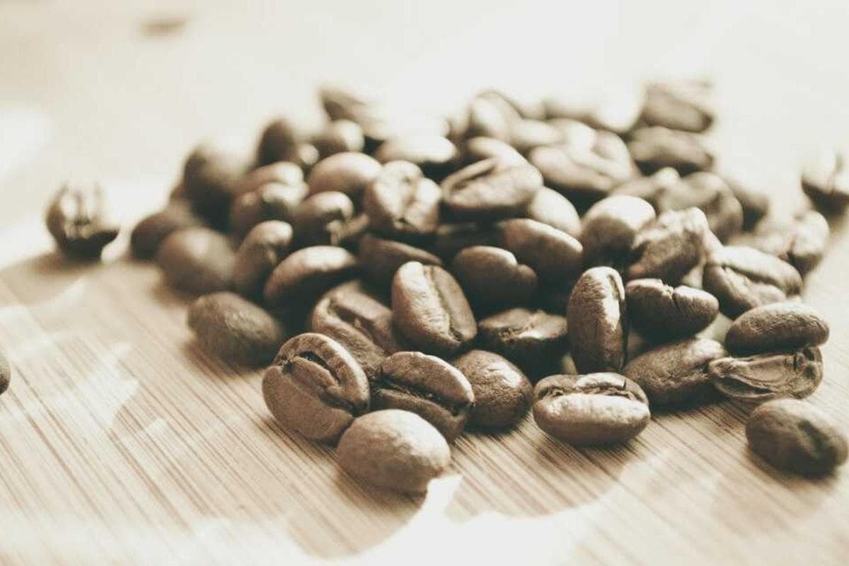Coffee beans scattered on a grained wooden board