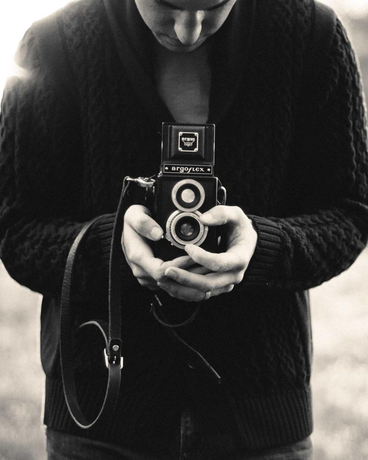 A filmmaker looking down into a twin-lens camera
