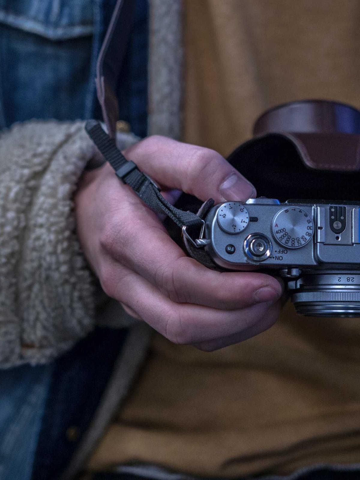 Hands cradling a rangefinder camera
